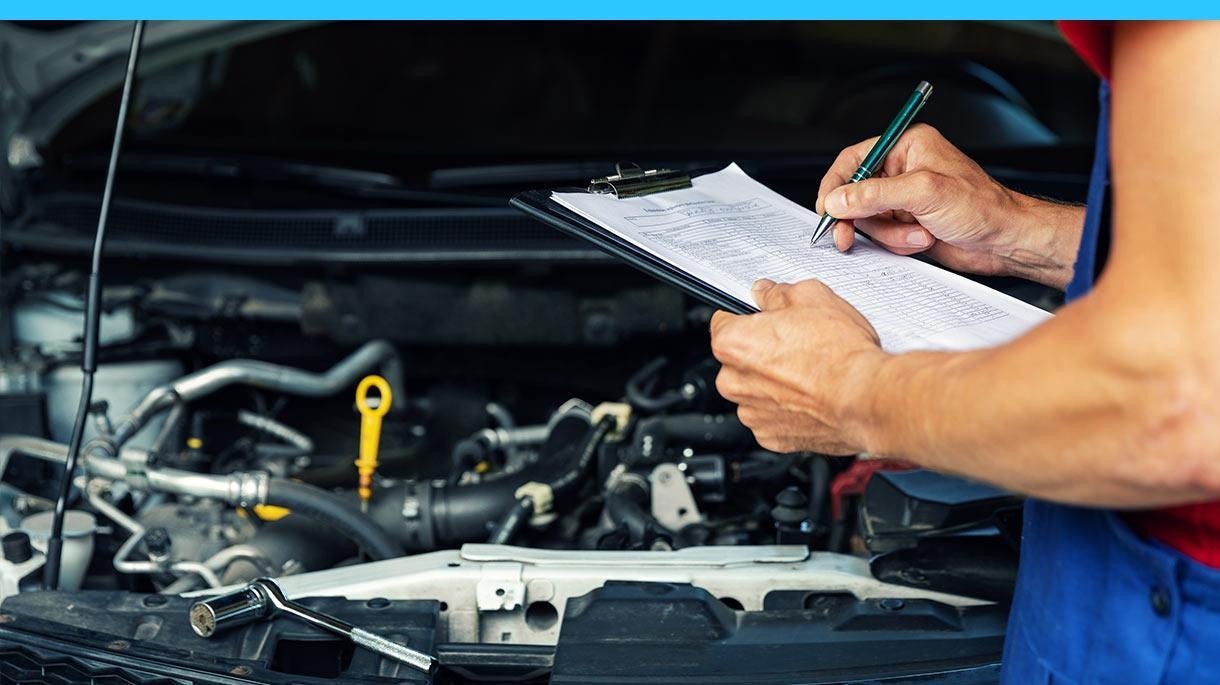 Mechanic with a clipboard inspecting a vehicle