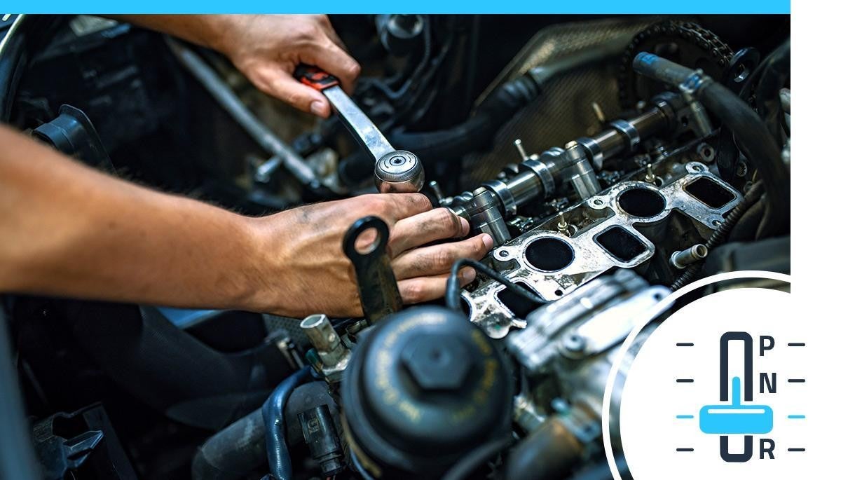 Service technician working on the engine of a vehicle.