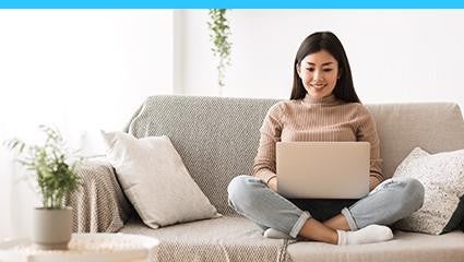 A Woman using laptop sitting on couch