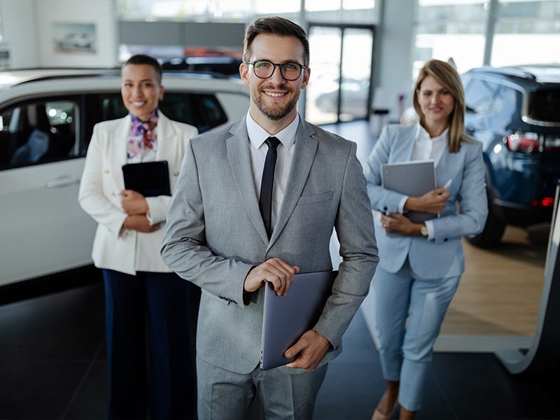 Three salspeople holding folders