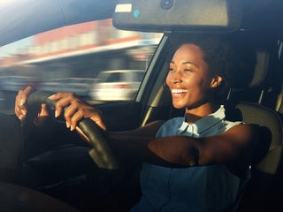 Happy and excited woman driving a car
